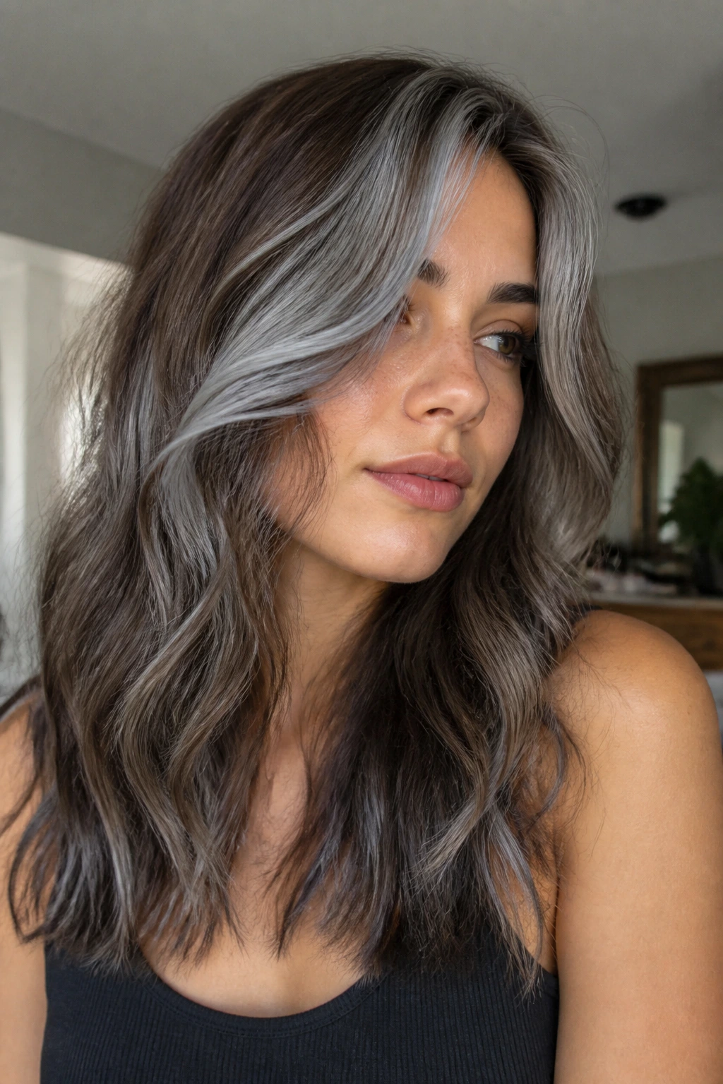 Portrait of a real woman with mushroom brunette and silver panels on wavy hair