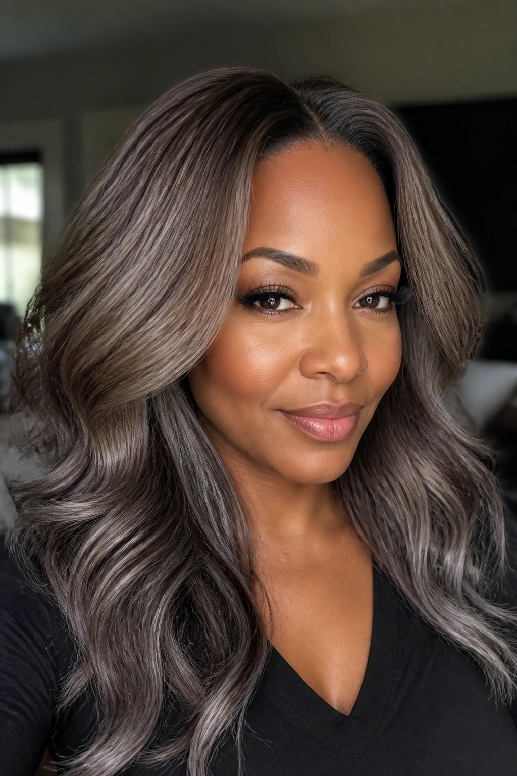 Portrait of a woman with varied grey-brown shades from roots to ends.