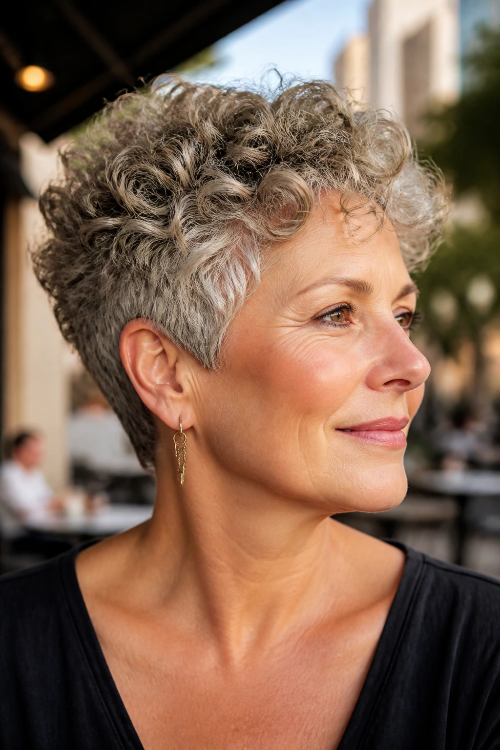 Close-up of a real woman with a neck-hugging curly crop in warm outdoor light