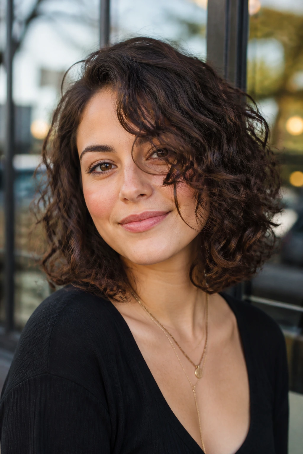 Portrait of real woman with off-center lob and curly curtain sweep