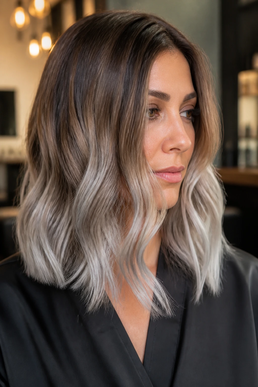 Close-up portrait of a real woman with a smoky bronze-to-silver ombre on shoulder-length hair