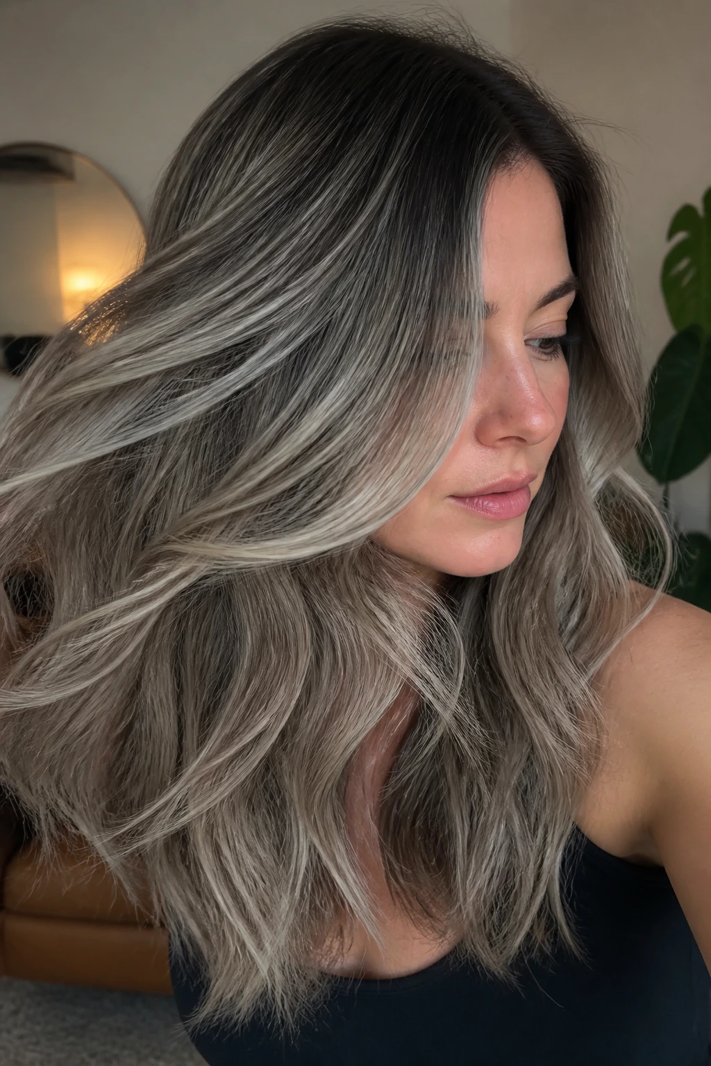 Close-up of a real woman with pebble grey balayage showing depth and ribbons