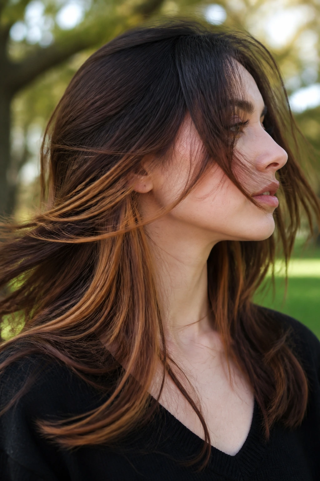 Close-up of hair showing peekaboo amber underlayers in motion