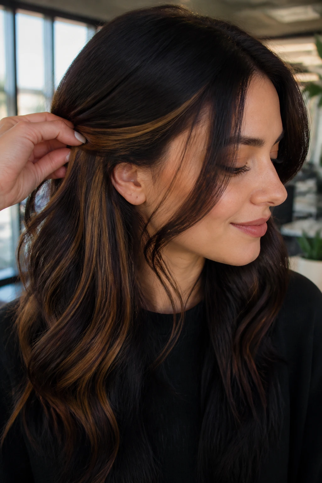 Real woman with hidden peekaboo caramel panels in hair in office lighting