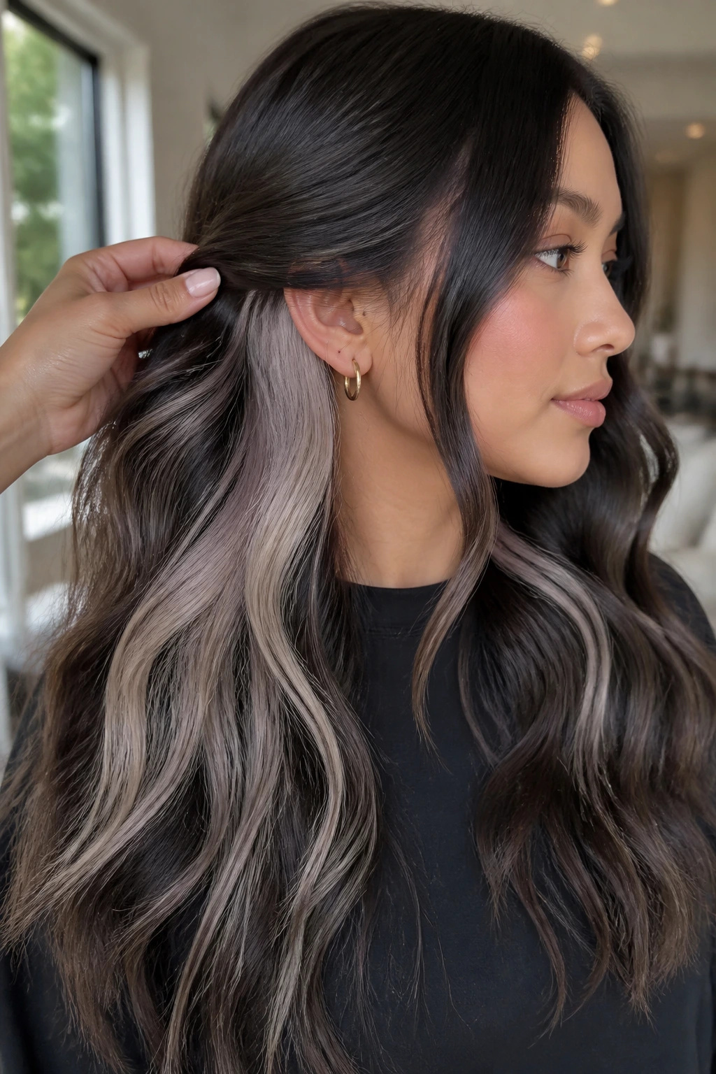 Close-up of icy beige peekaboo pieces under dark wavy hair on a real person