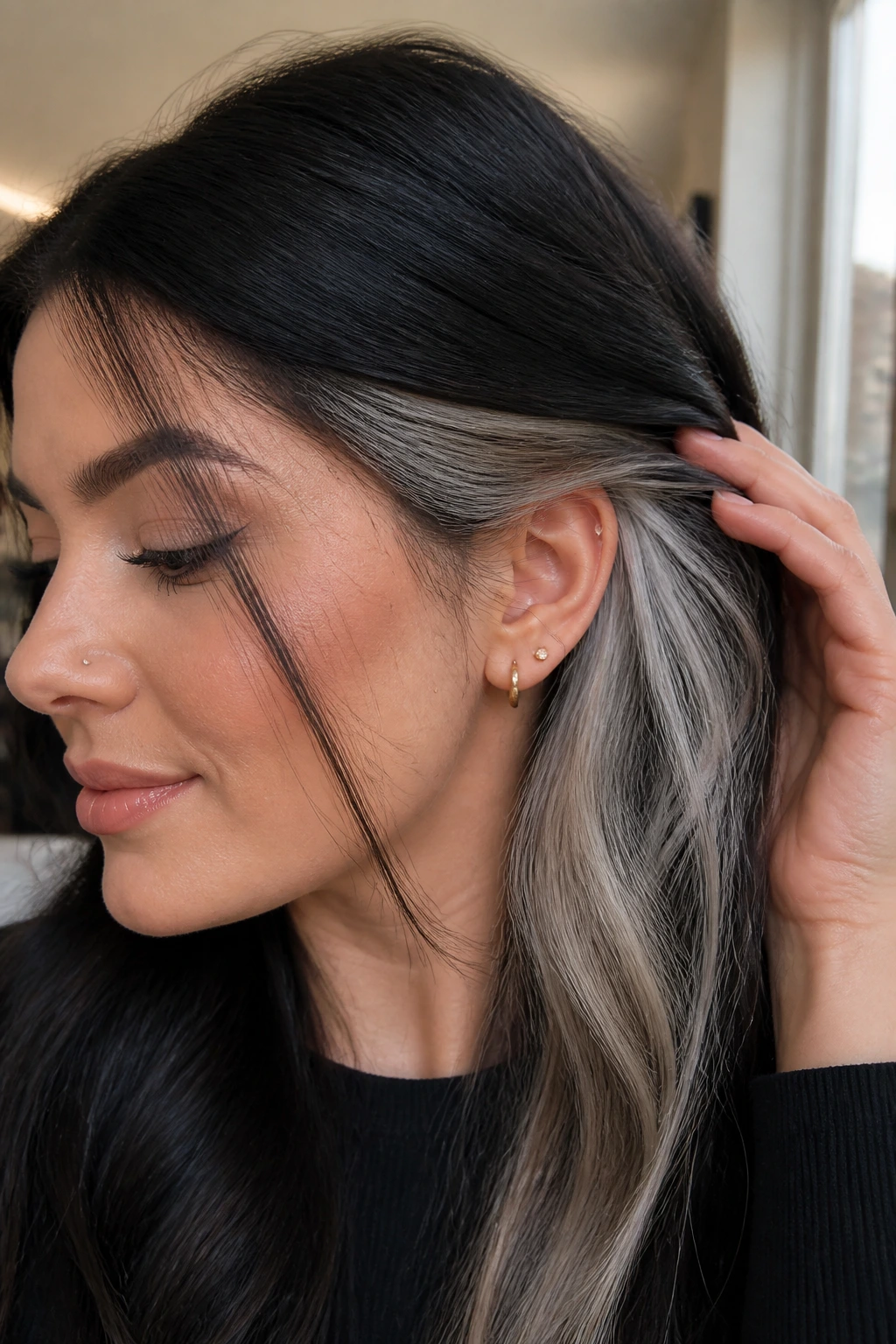 Close-up portrait of a real woman showing hidden platinum under dark hair layers.