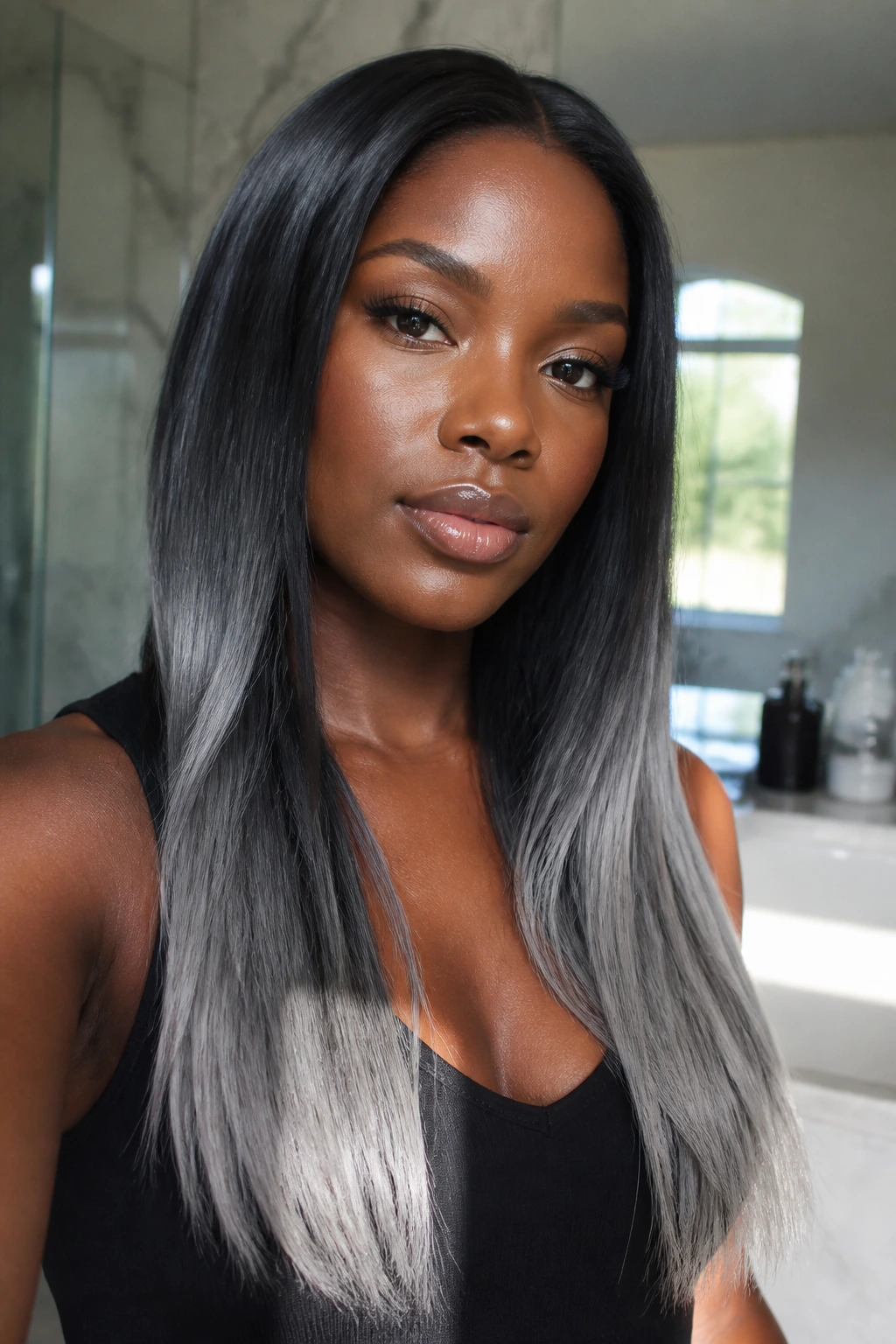 Close-up portrait showing pewter-gray ends on long straight hair with dark roots.