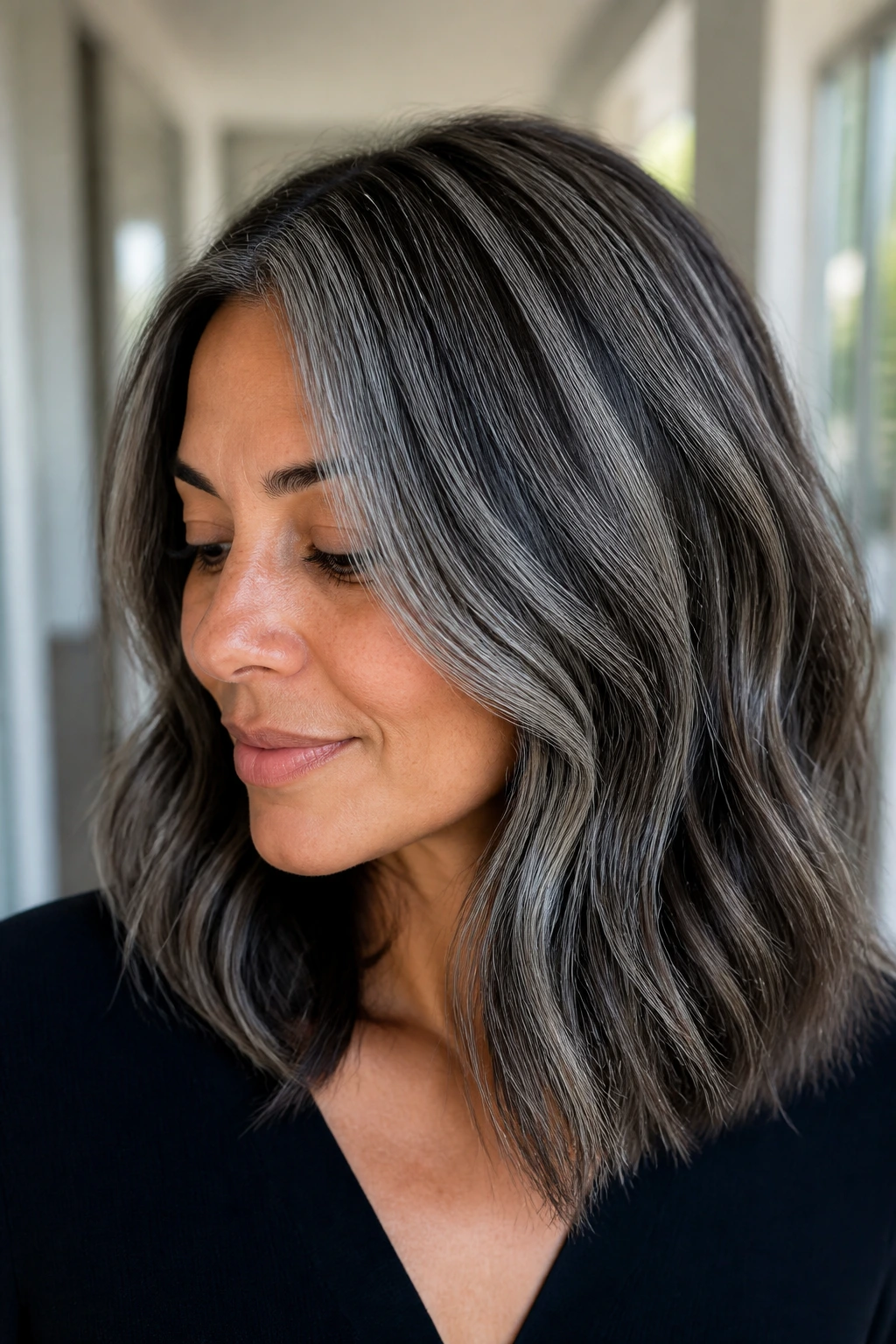 Close-up portrait of a woman with pewter highlights in shoulder-length hair
