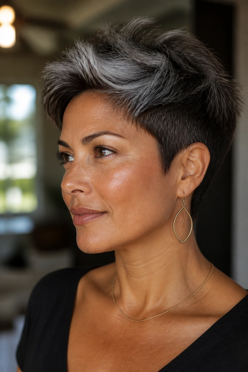 Head-and-shoulders portrait of a real person with a dark brown pixie and silver crown in bright natural light.