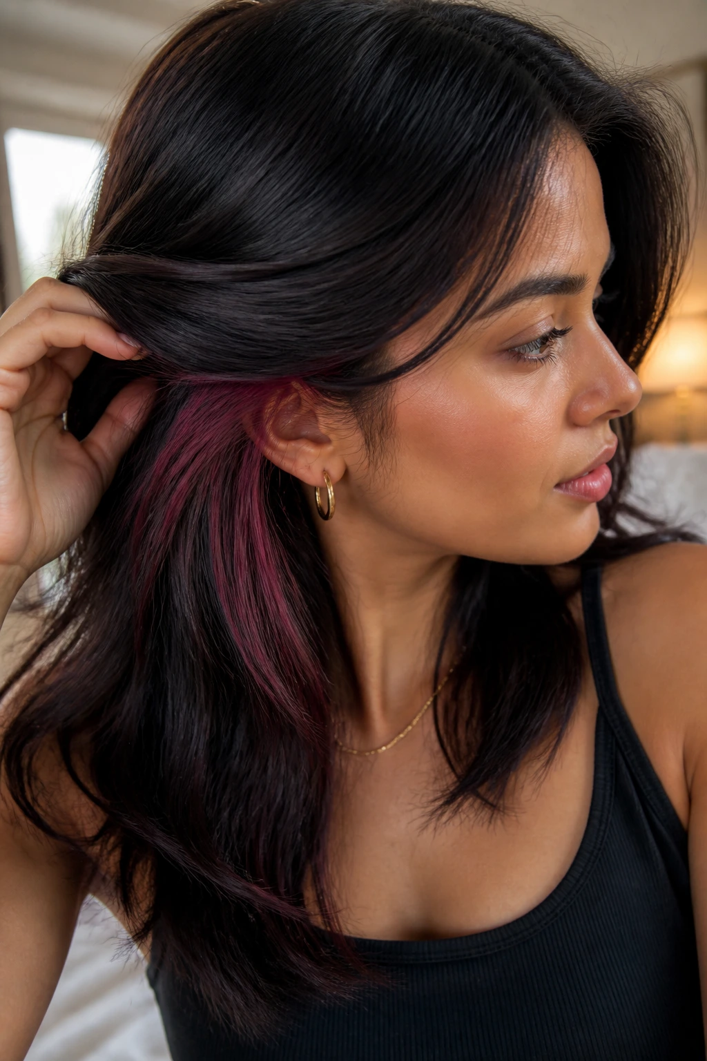 Close-up of person with hidden plum streaks under the top hair layer in warm natural light