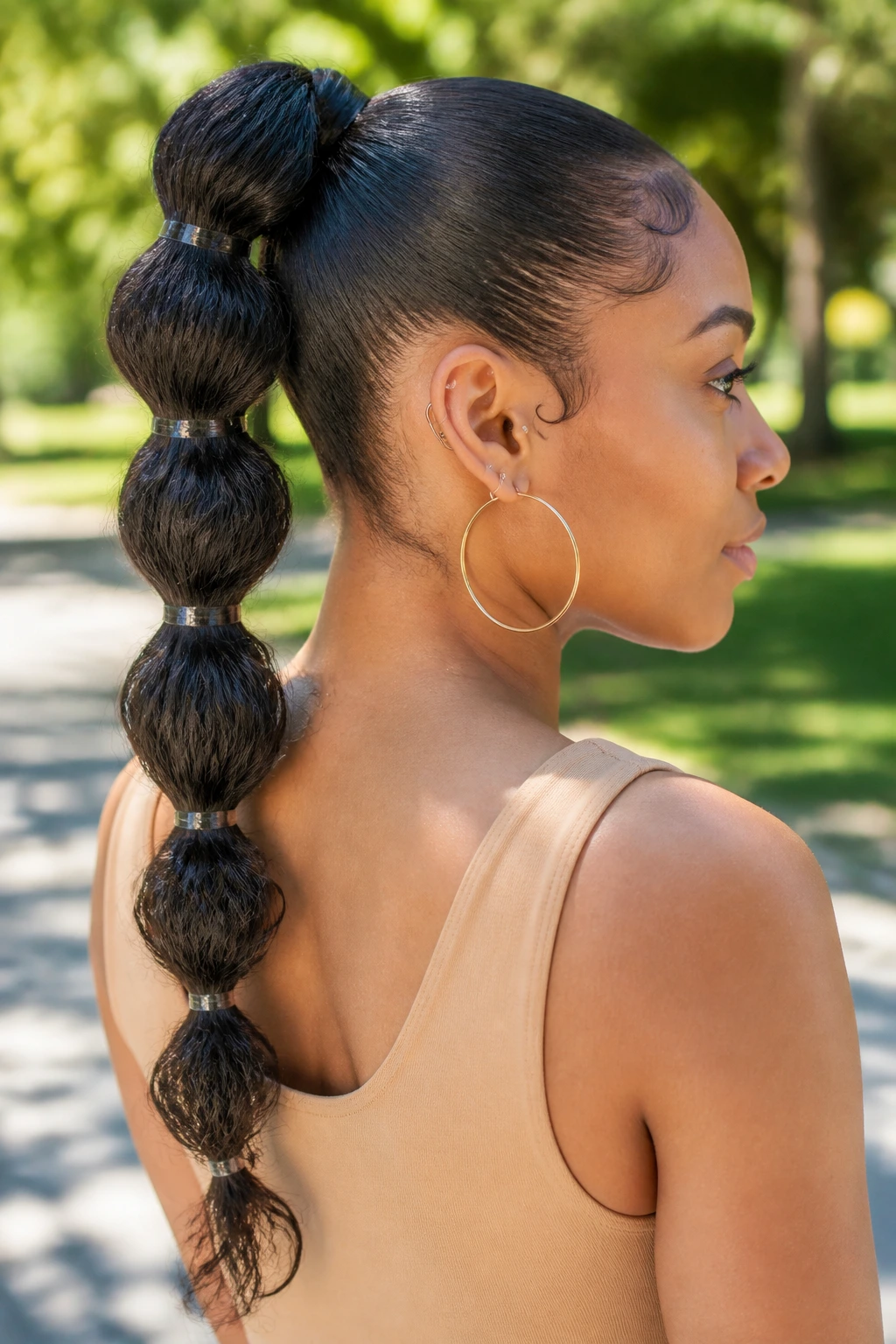 Close-up of a pull-through bubble braid in a ponytail on a real woman outdoors