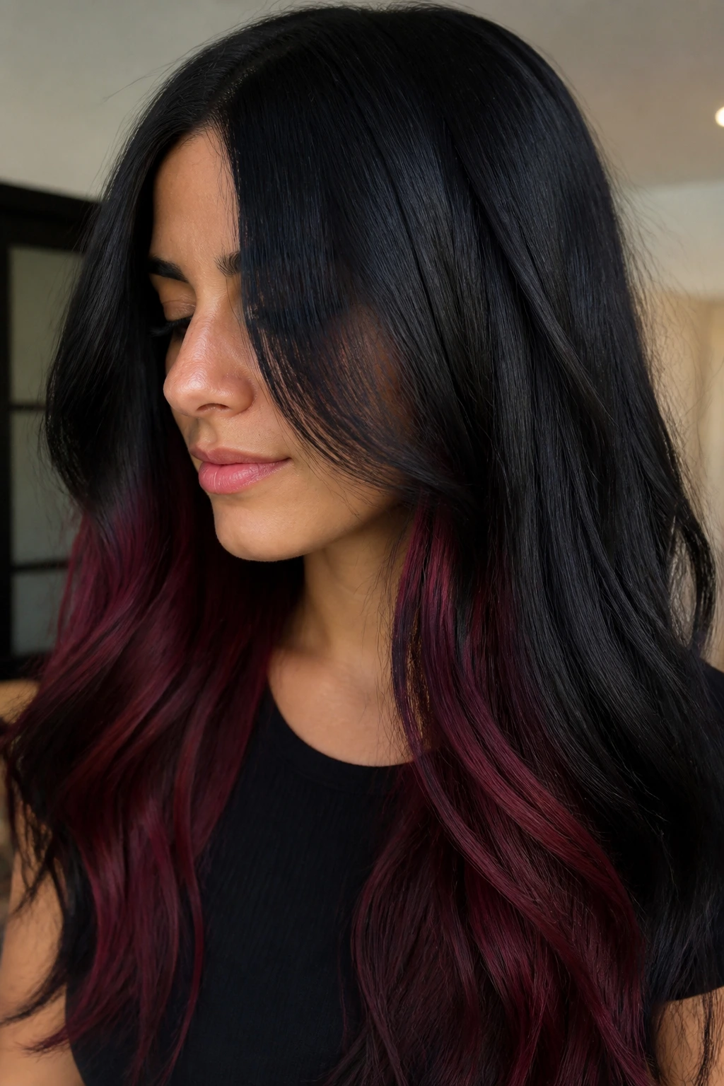 Portrait of raven-black hair with subtle burgundy peekaboo panels.