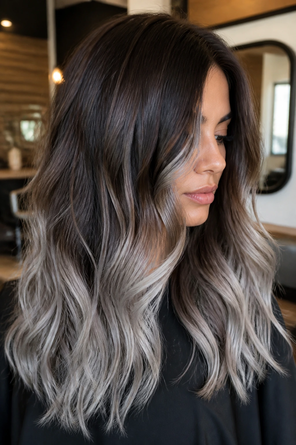 Brunette with reverse balayage showing darker roots and silver ends.