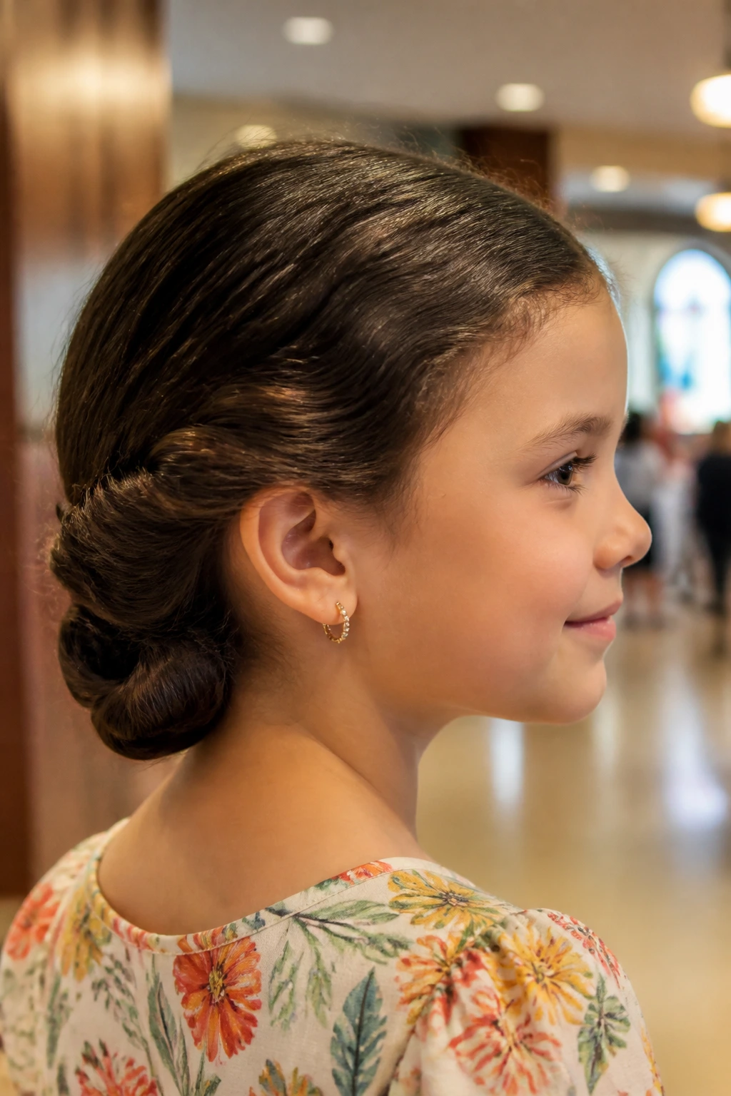 Close-up of a real girl with a rolled low twist knot hairstyle in a church foyer.