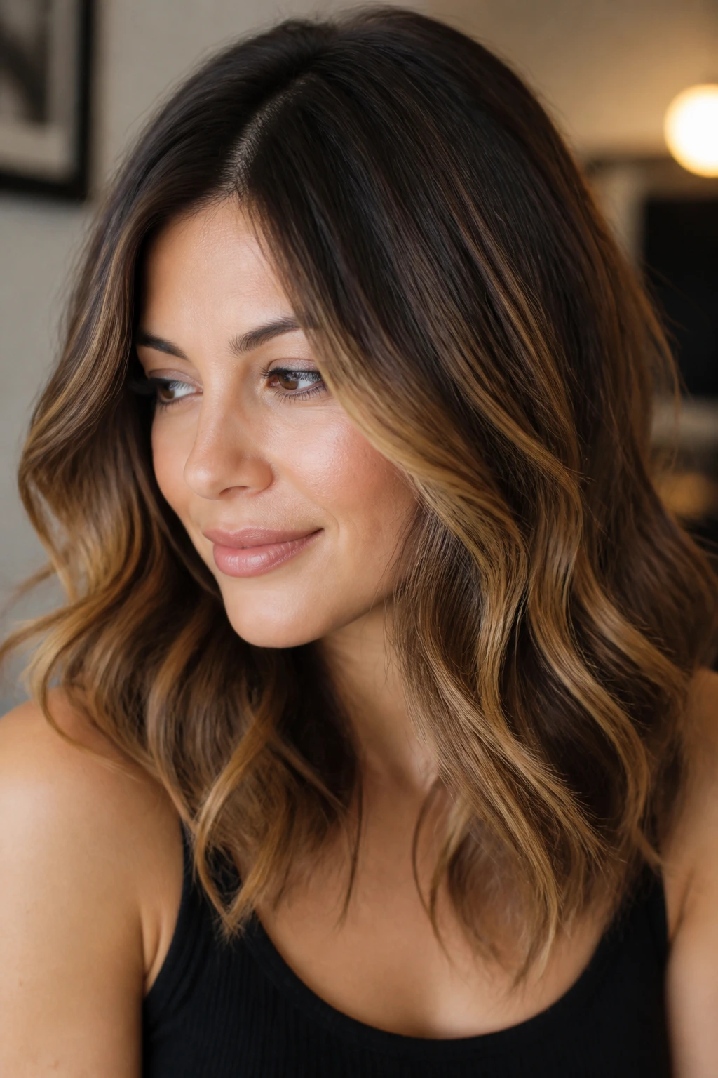 Close-up of a real woman with rooted caramel sweep through hair