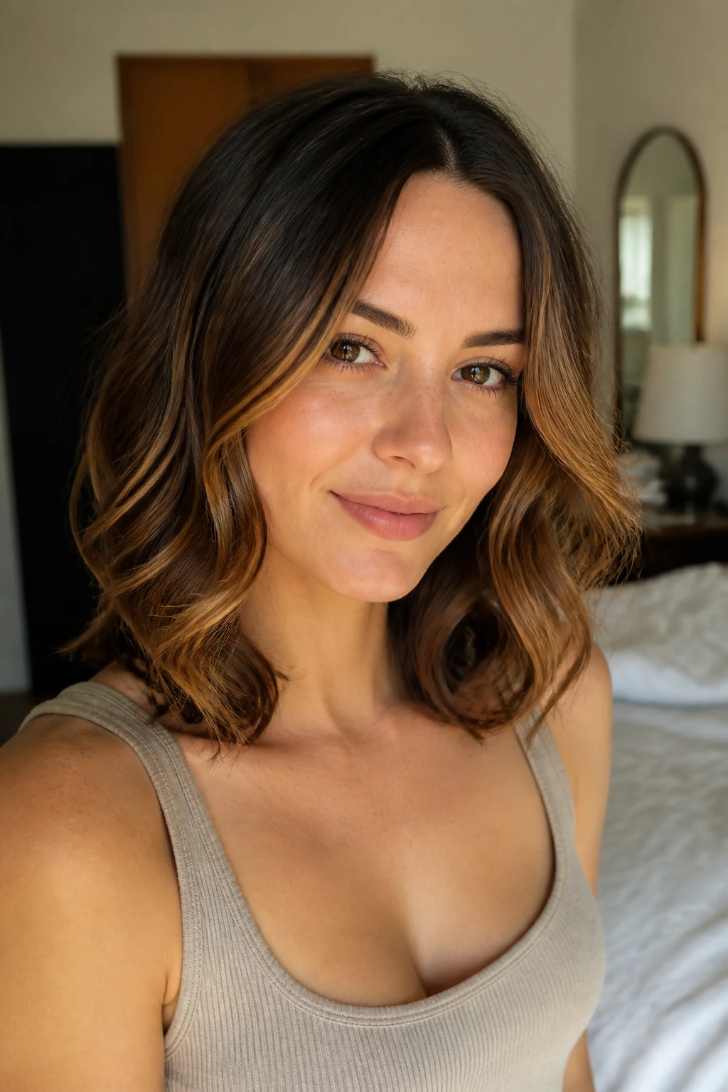 Close-up of a real woman with rounded collarbone-length curls and a middle part.