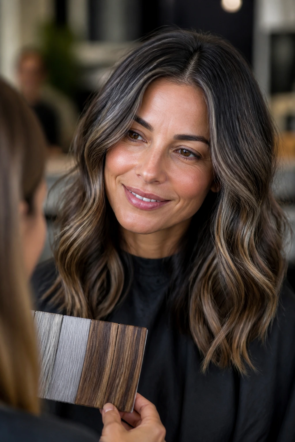 Real client in a salon chair with grey and caramel color discussed with stylist