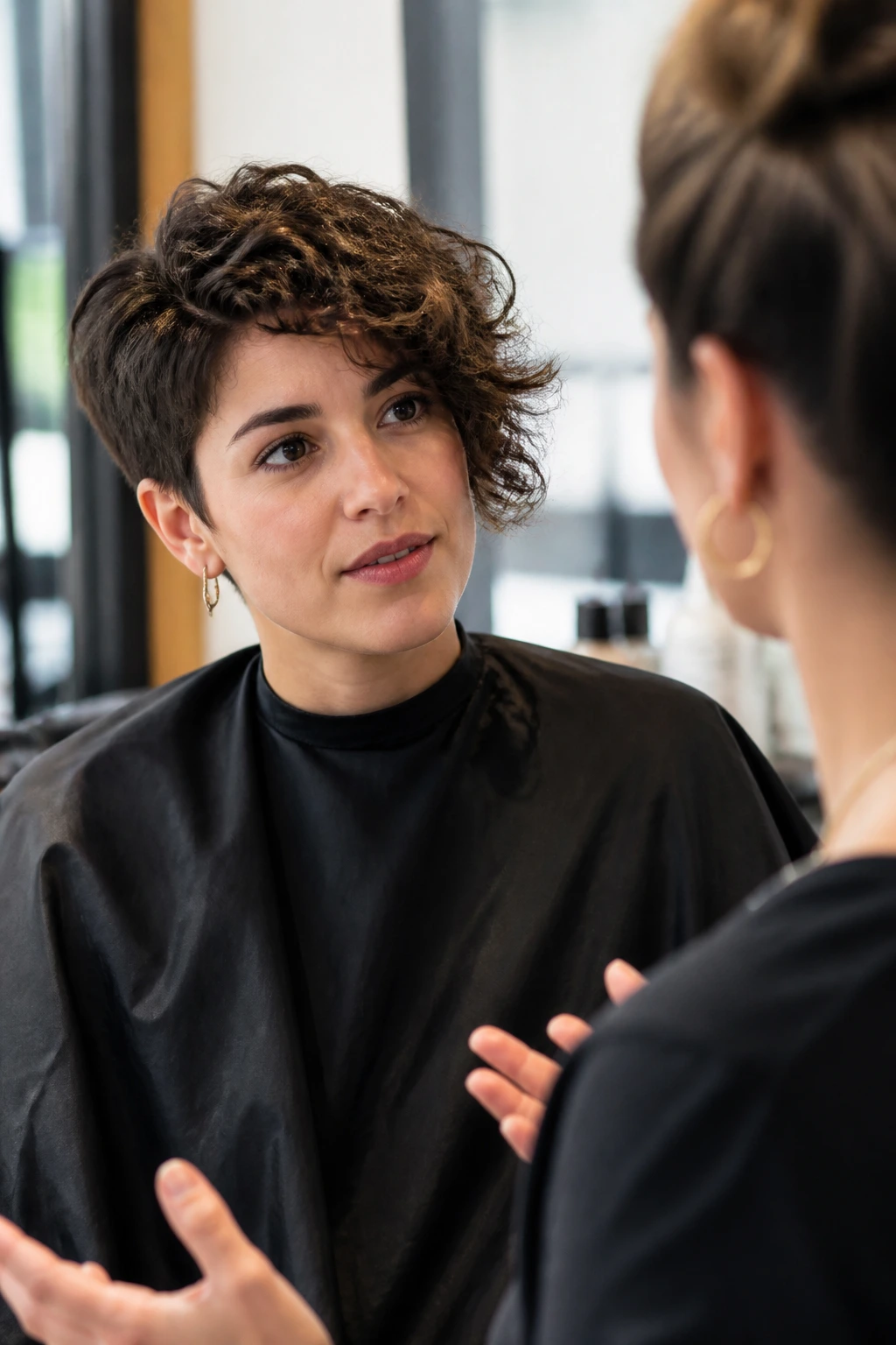 Close-up of a client discussing a haircut with a stylist in a salon