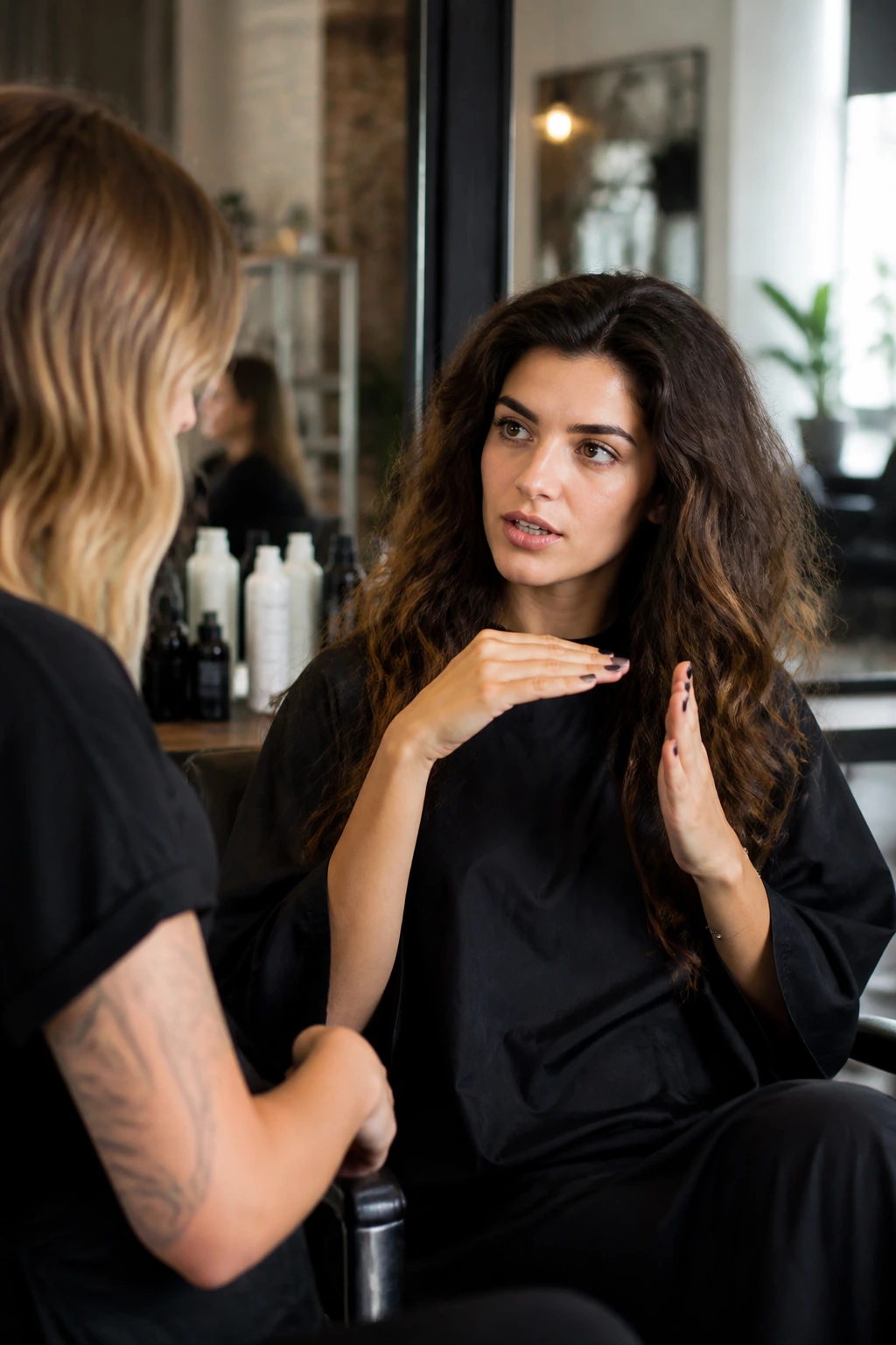 Client in salon discussing haircut with stylist about avoiding puffiness