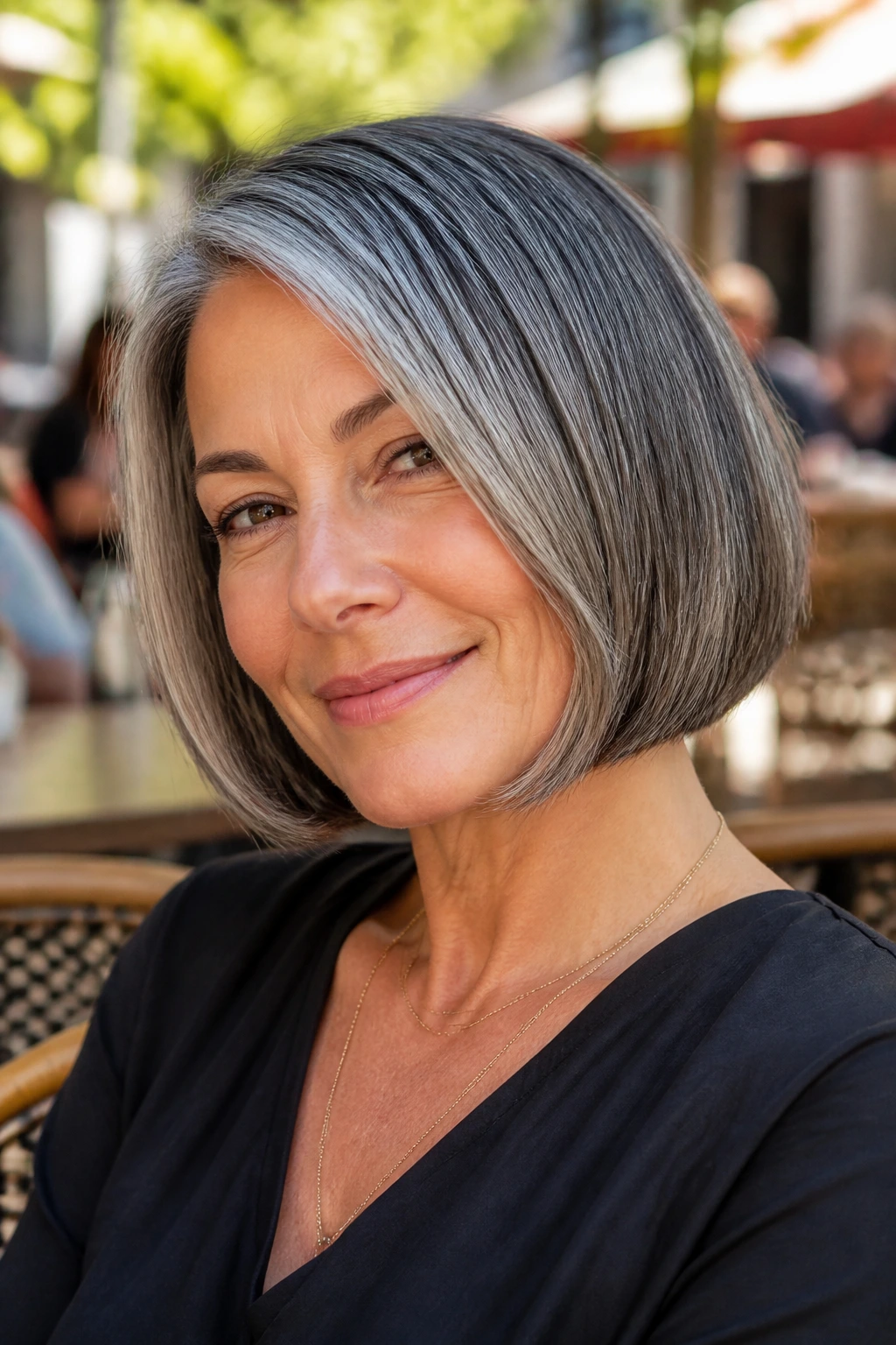 Close-up of a real woman with a salt-and-pepper round bob in outdoor light