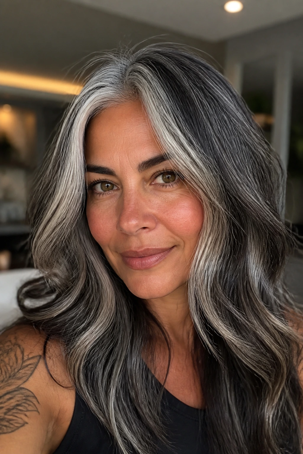 Close-up of a real woman with salt-and-pepper hair and face-framing highlights