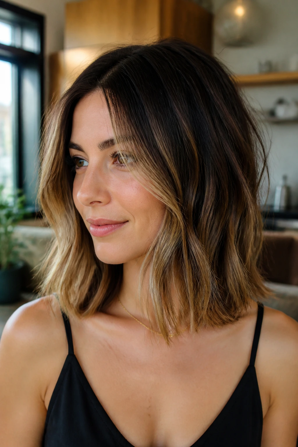 Medium close-up of a woman with shadow-root collarbone-length lob