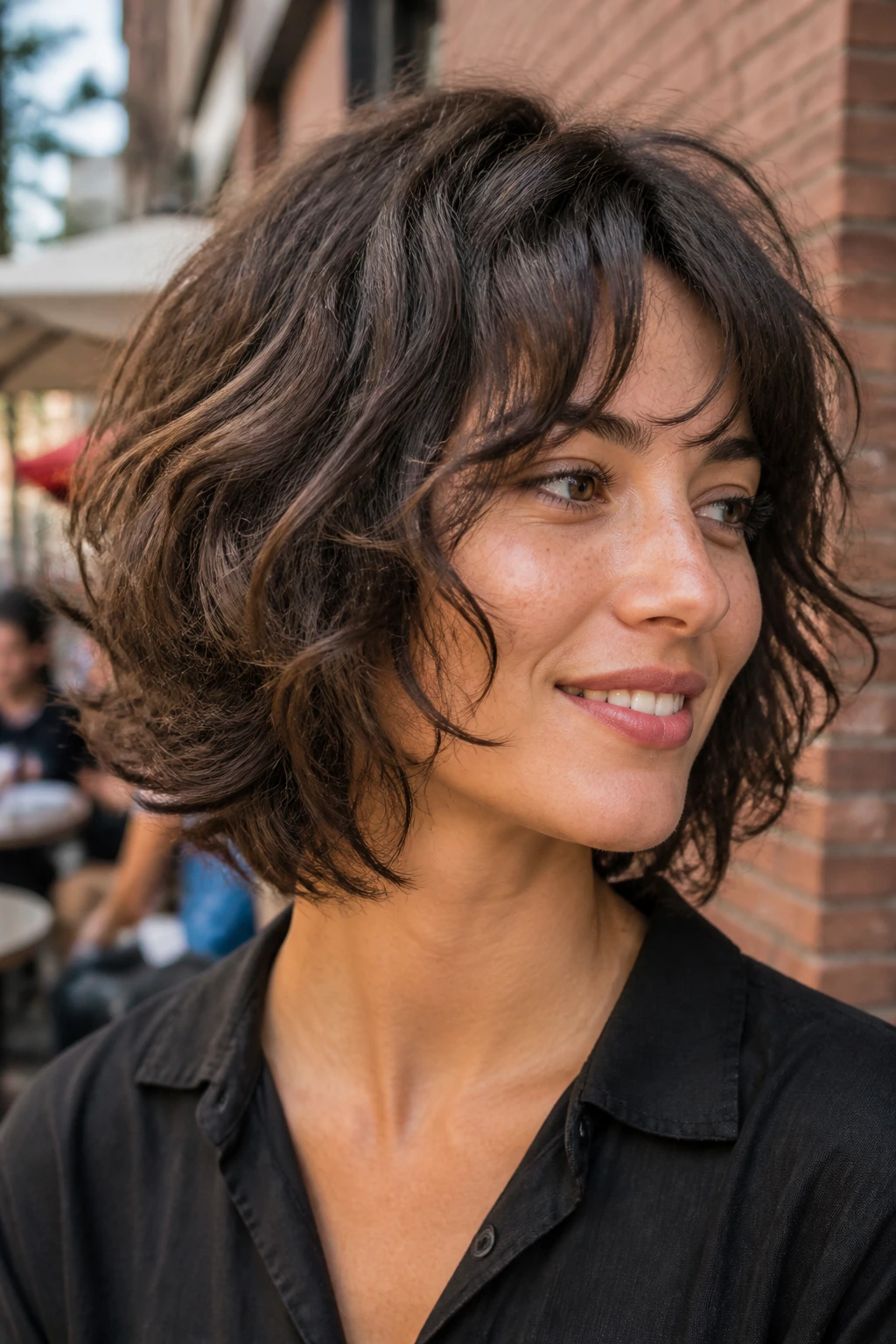 Close-up portrait of a real person with a shattered layer bob showing irregular feathered layers and separated curls.