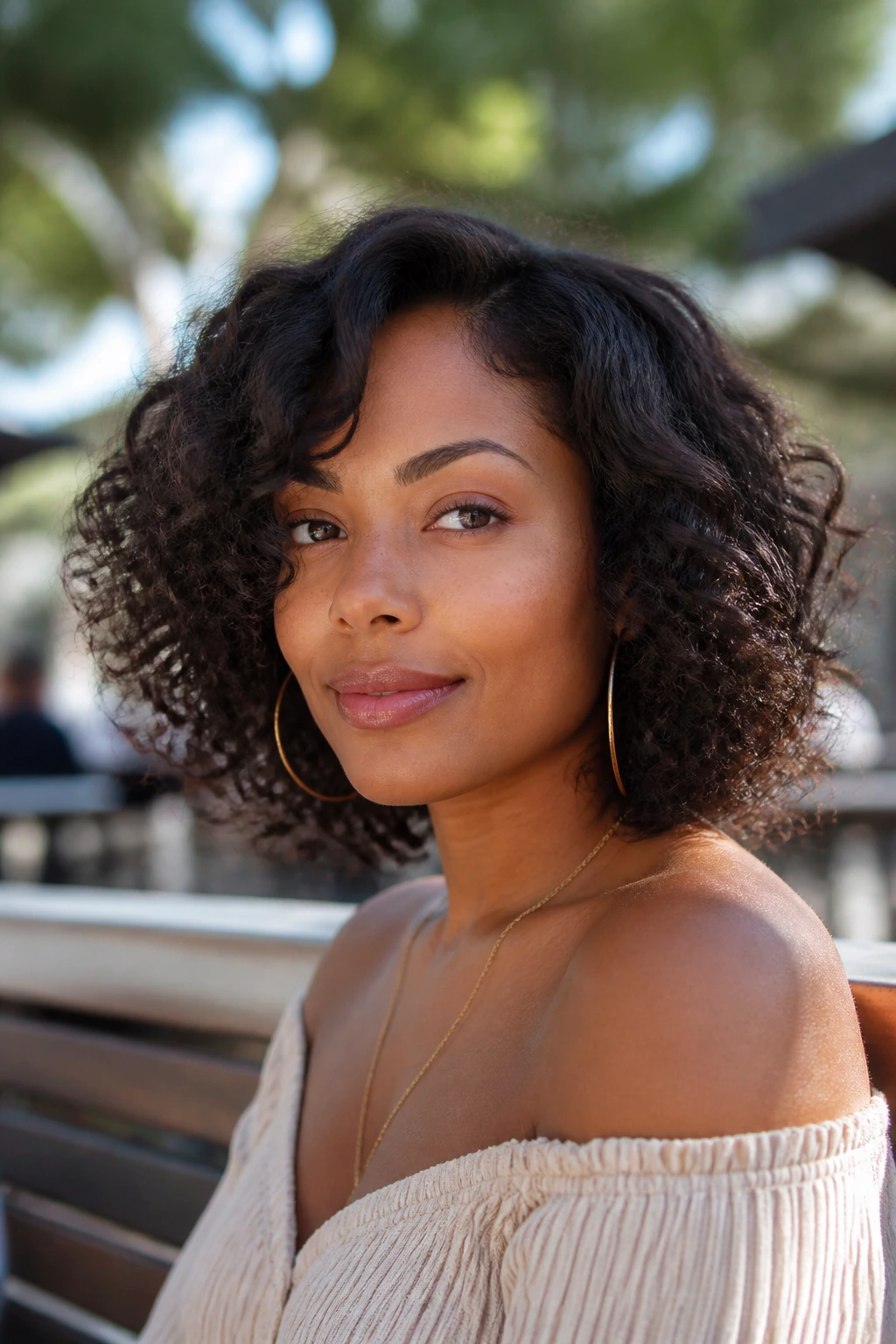 Close-up of a Black woman with shoulder-skimming layered bob and natural curls