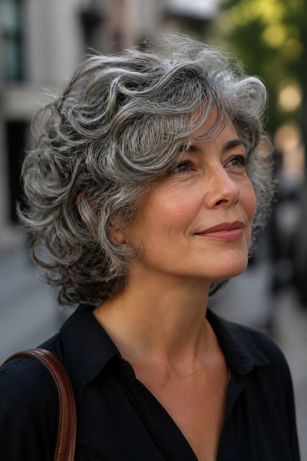 Real woman with side-swept fringe in curly hair, portrait in outdoor light.