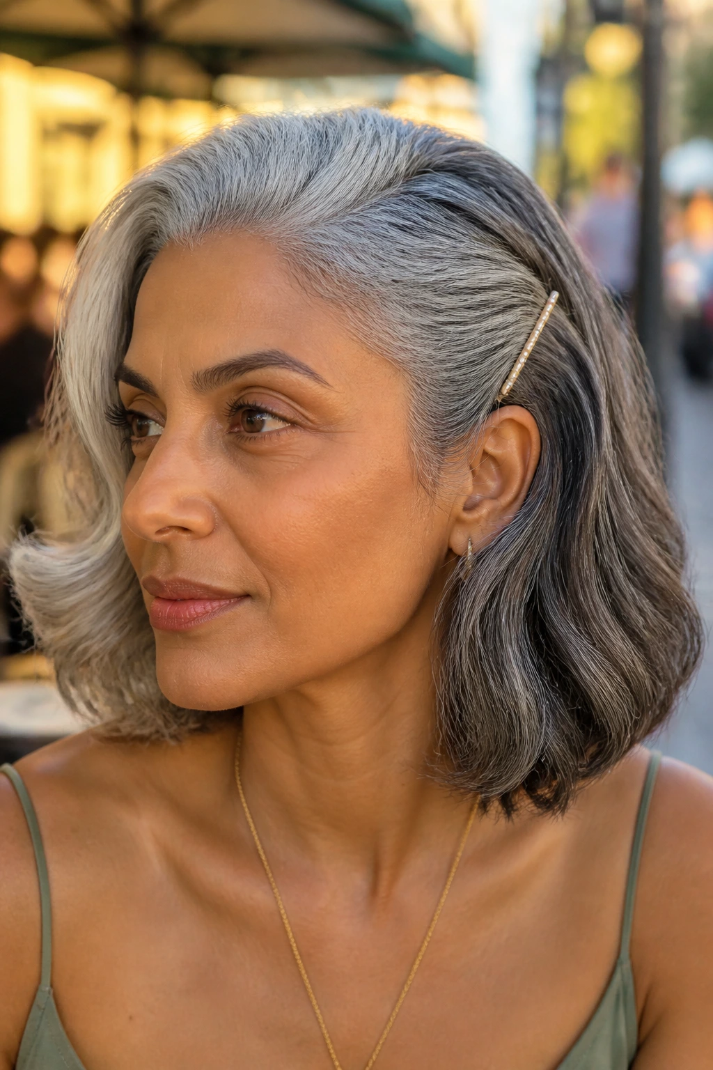 Close-up of a real woman with a soft side-swept wave and temple pin near the temple.