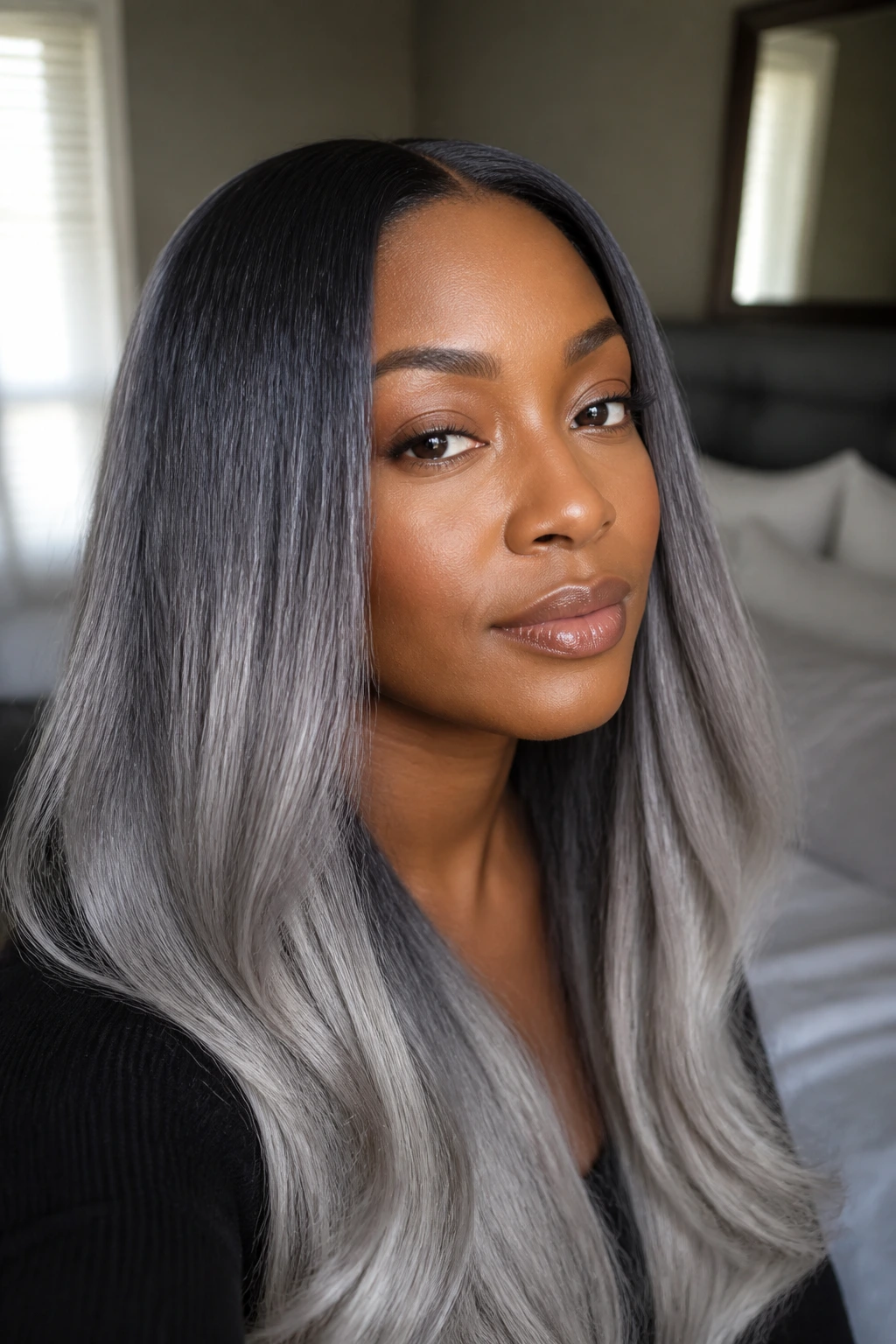 Close-up of a real person with silk-pressed hair showing dark roots and silver ends.
