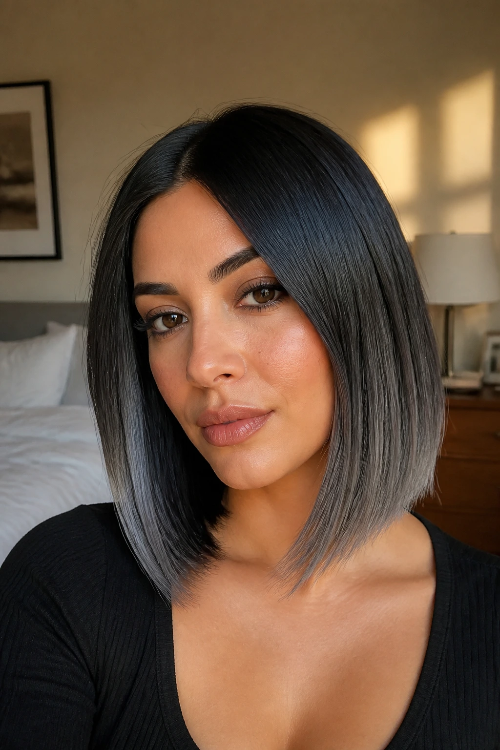 Close-up portrait of a real woman with a silver-blended sleek lob featuring a black base and silver tips, warm window light
