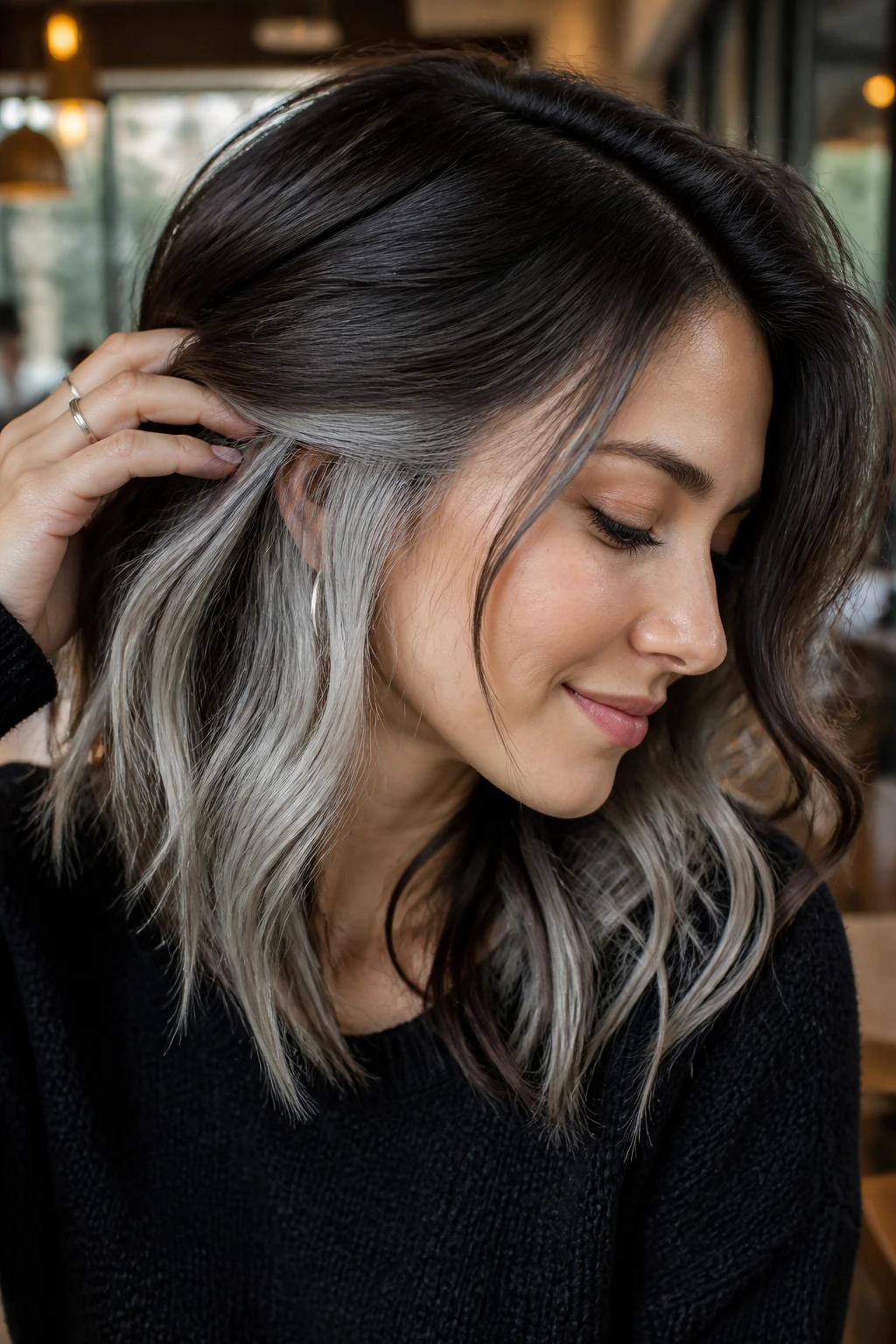 Close-up of brunette hair with silver peekaboo panels revealed, on a real person.
