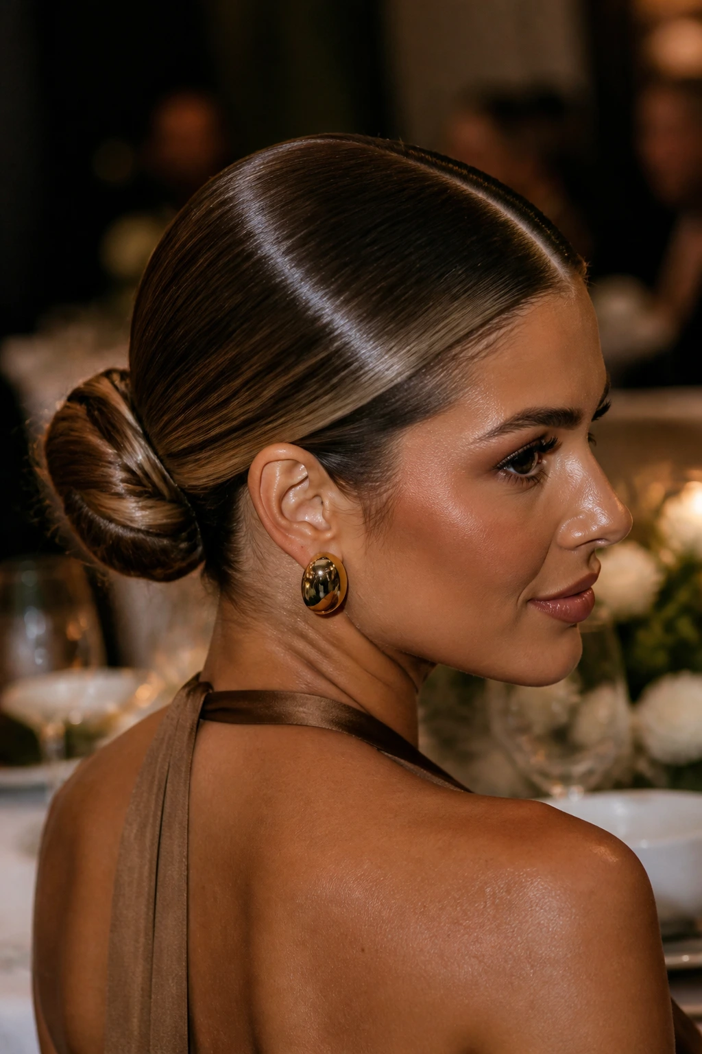 Close-up of real woman with bronze gloss sleek bun and center part