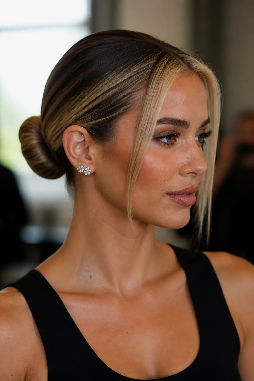 Portrait of a real woman with a slicked-back bun and bright front streaks.