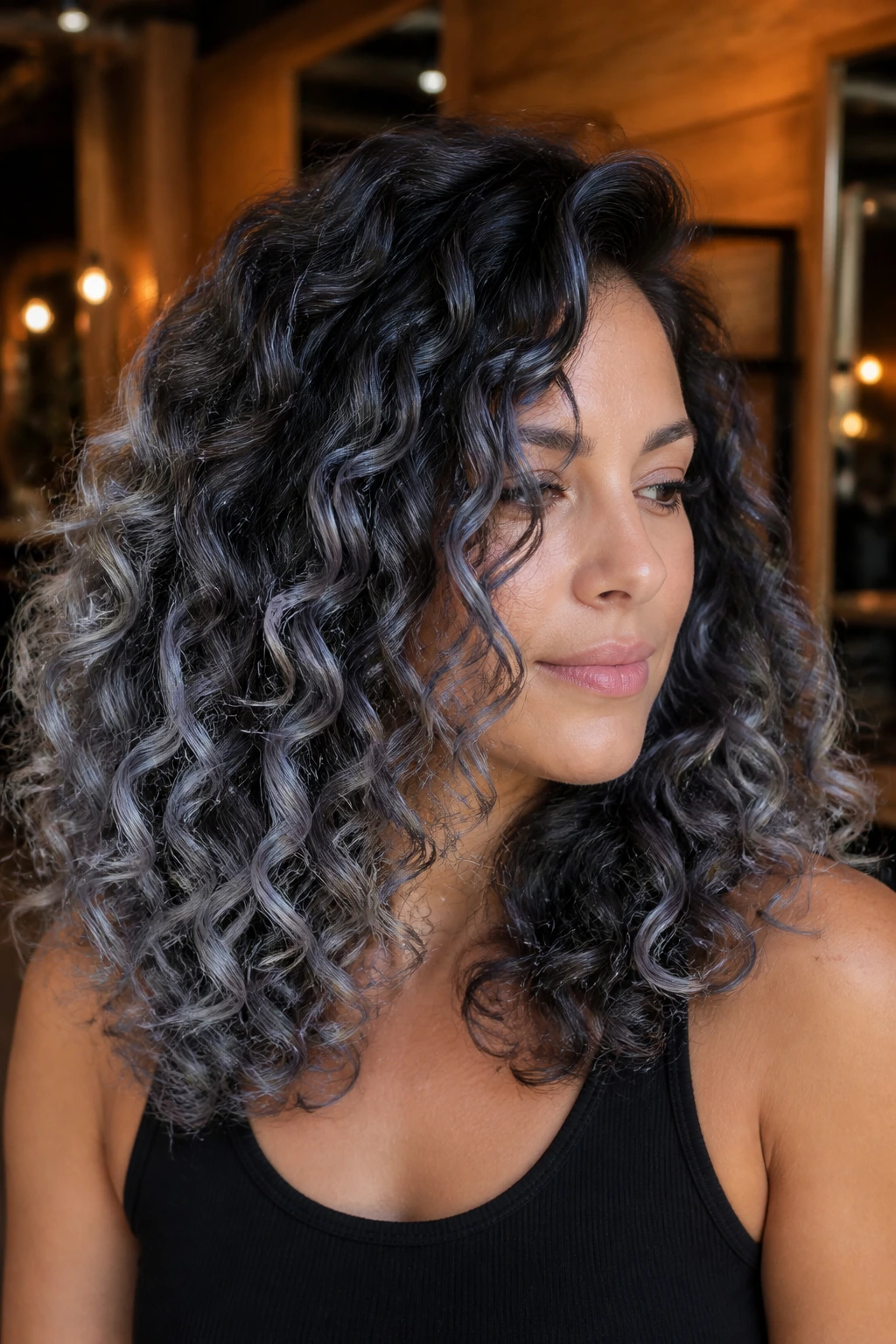 Close-up of brunette curls with smoky silver balayage on mid-lengths and ends