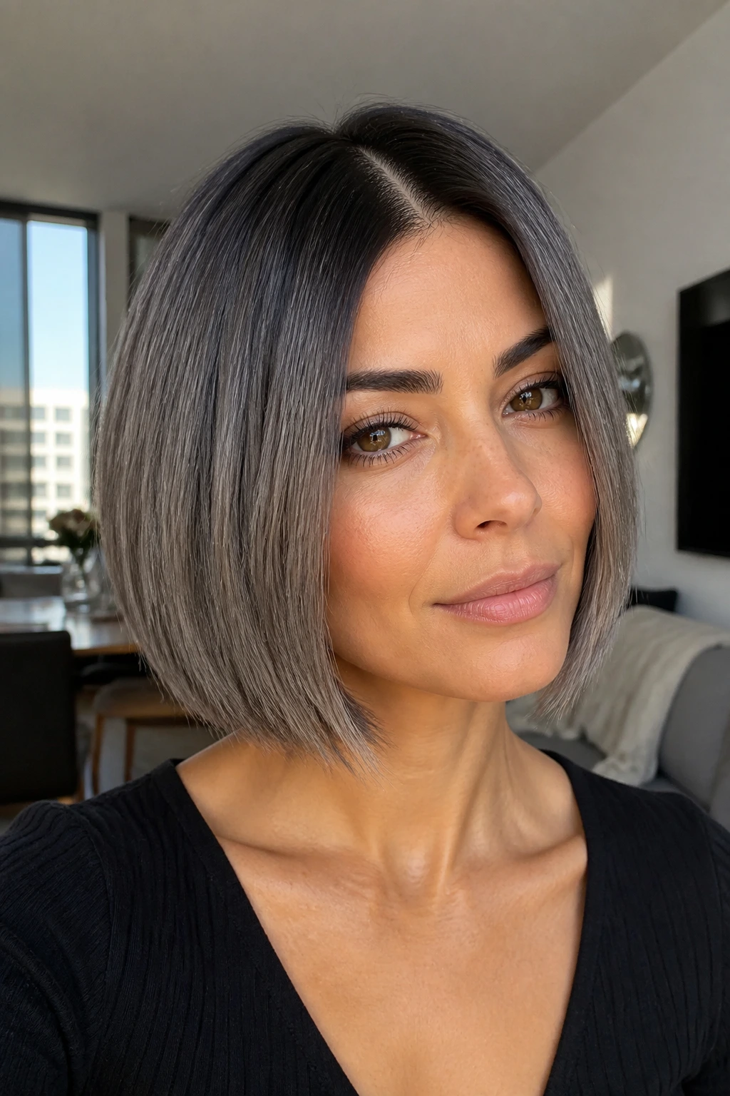 Close-up of olive-skinned woman with chin-length smoky blunt bob and dark roots