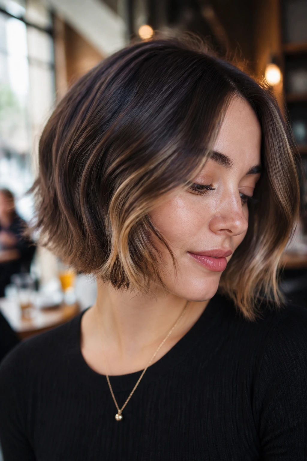Close-up of a real woman with smoky brunette bob and honey peekaboo panels