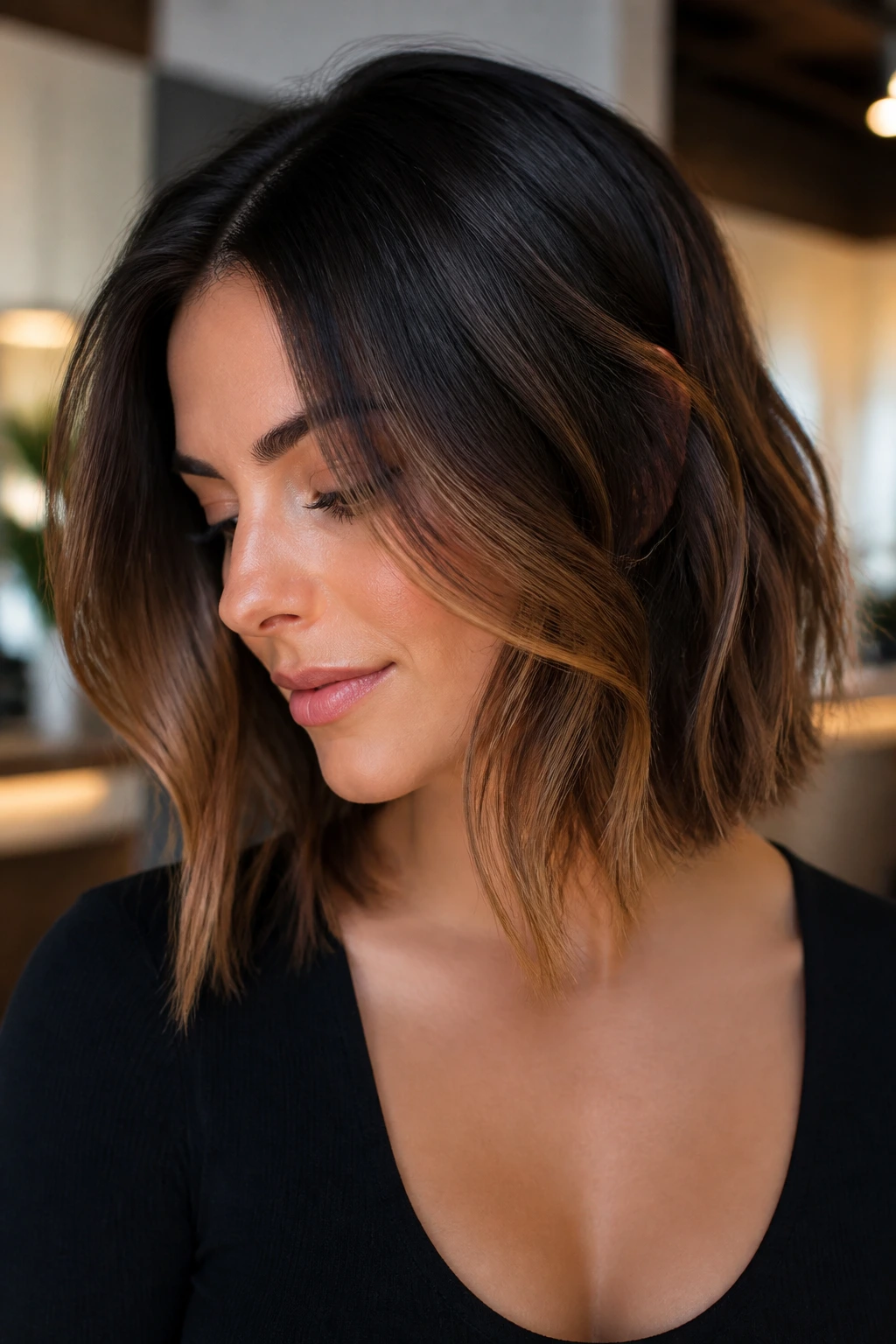 Close-up of smoky brunette lob with caramel underlights on a real person