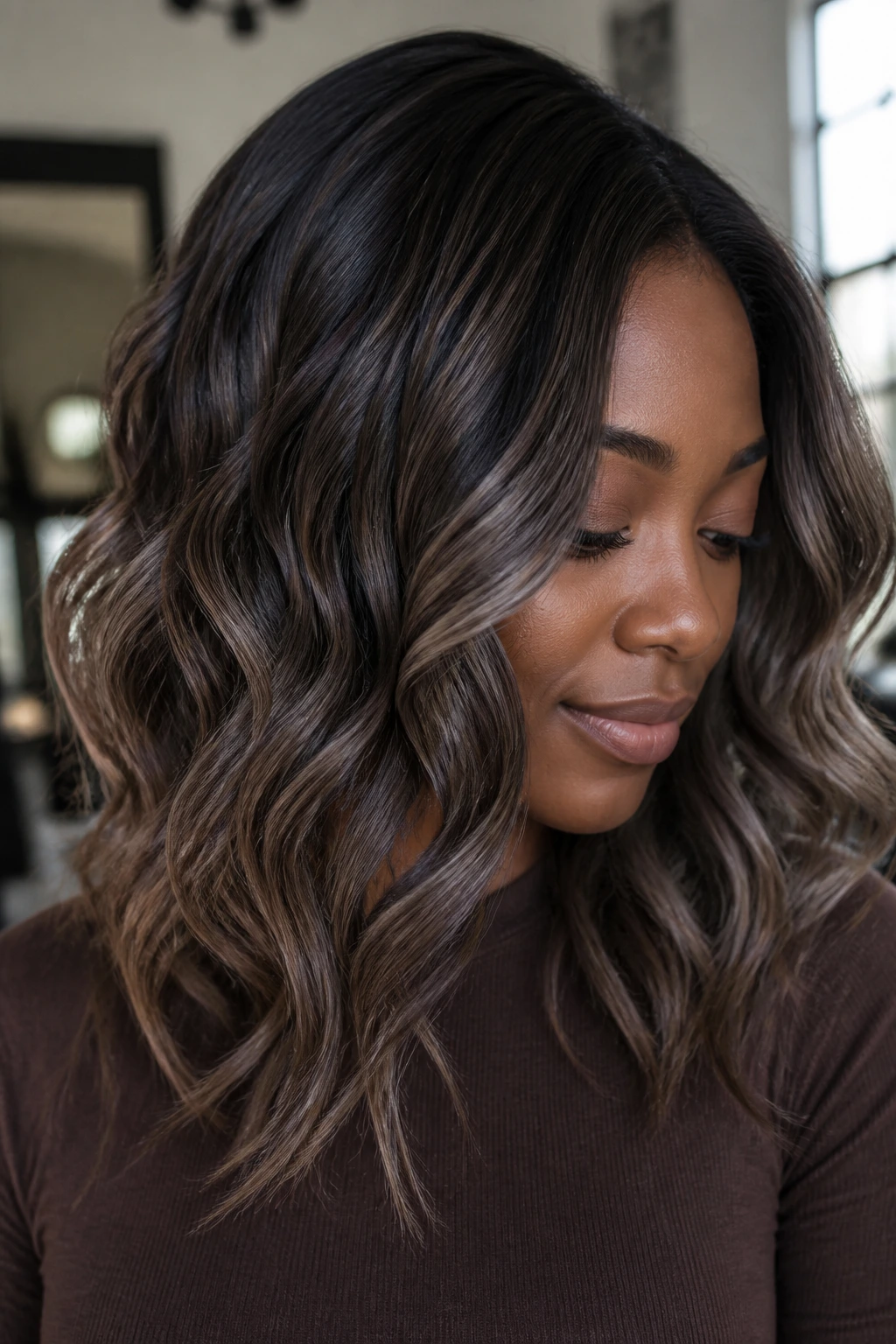 Close-up of smoky cocoa balayage on deep skin with ash highlights