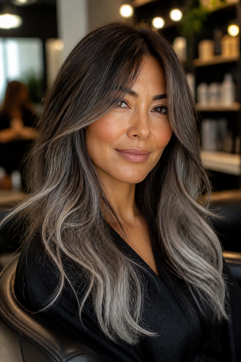 Close-up of a real woman with smoky mocha hair fading to silver ends, curtain bangs