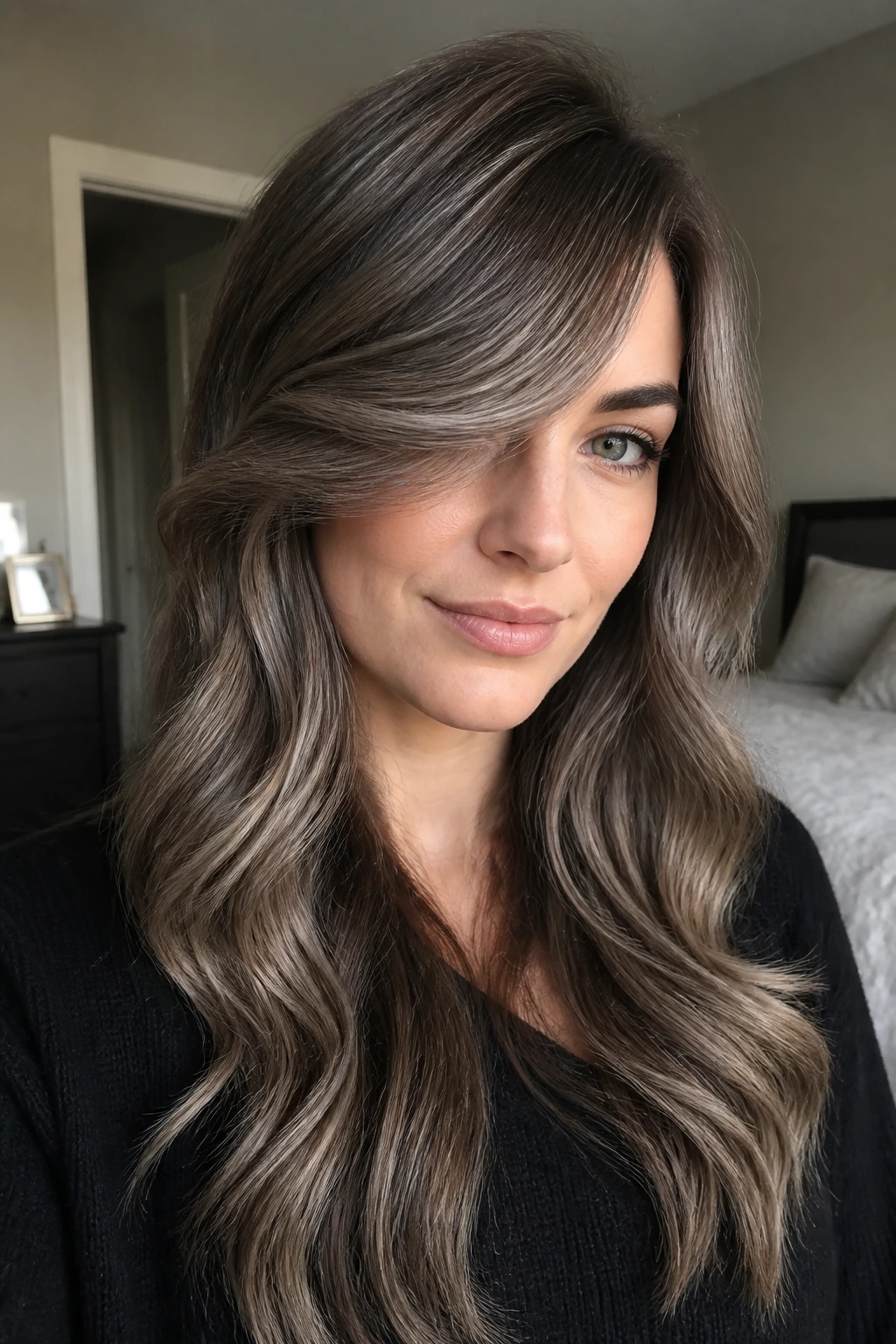 Close-up of a real woman with smoky mushroom balayage and diagonal side-swept bangs.