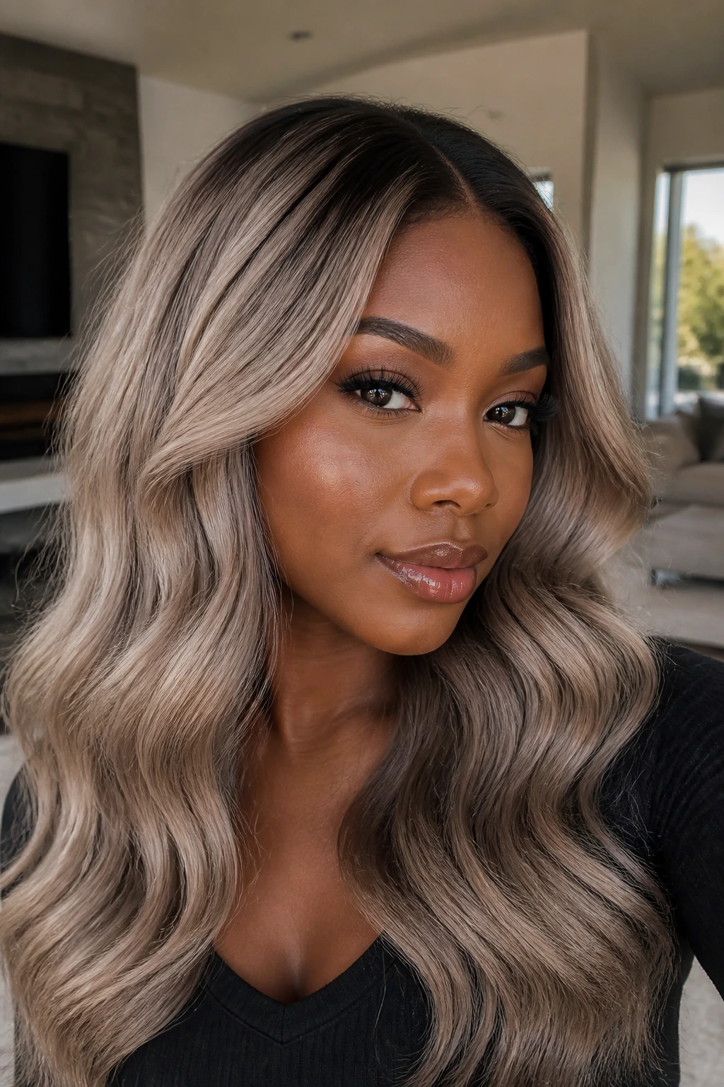 Close-up of woman with smoky mushroom blonde and dark root on deep skin.