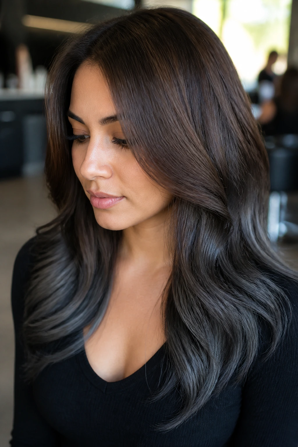 Close-up of smoky ash-black ombre on medium brunette hair on a real person