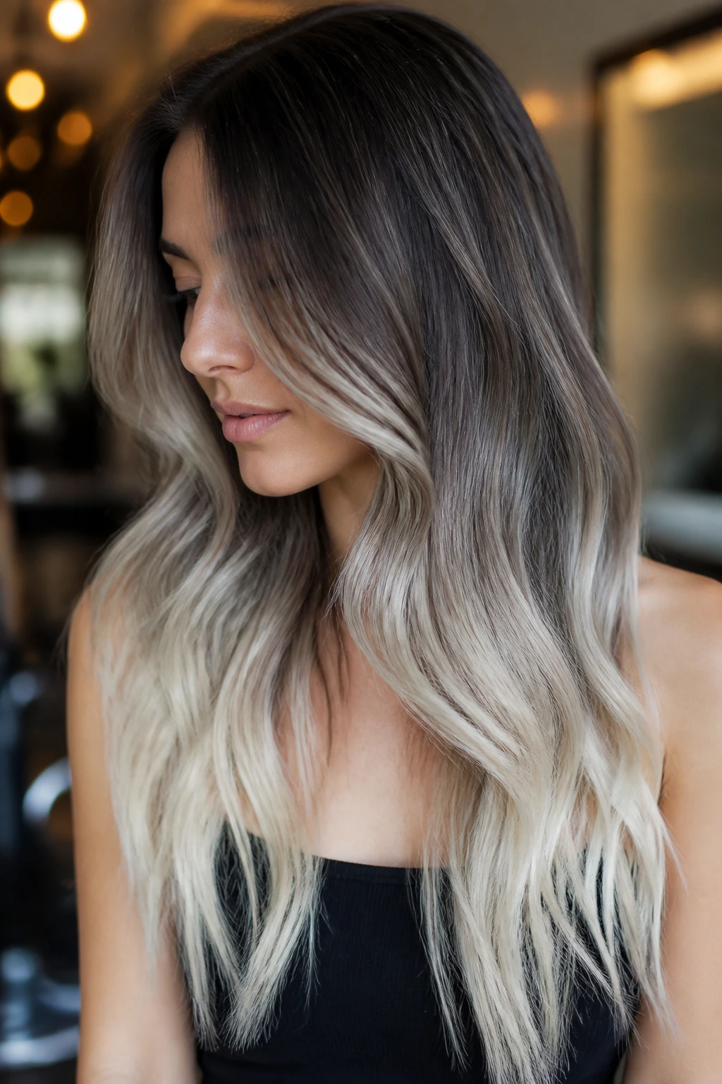 Close-up of long hair with smoky roots transitioning to platinum ends on a real person