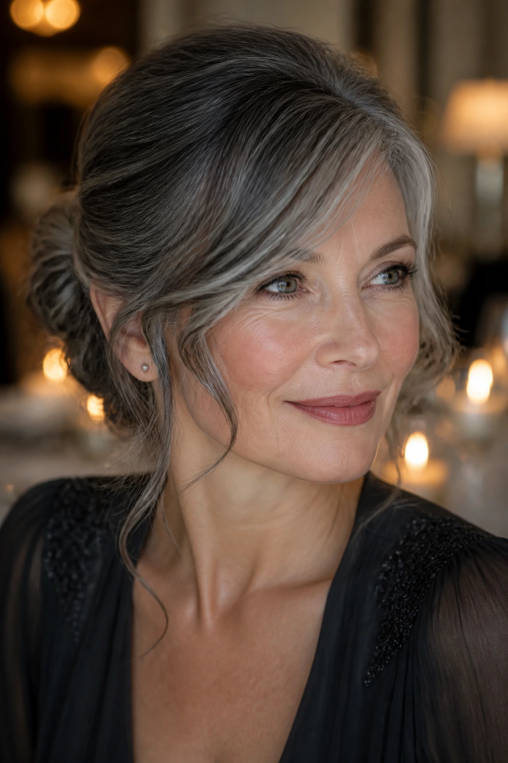 Close-up portrait of a real woman with a soft graphite updo and side-swept tendrils