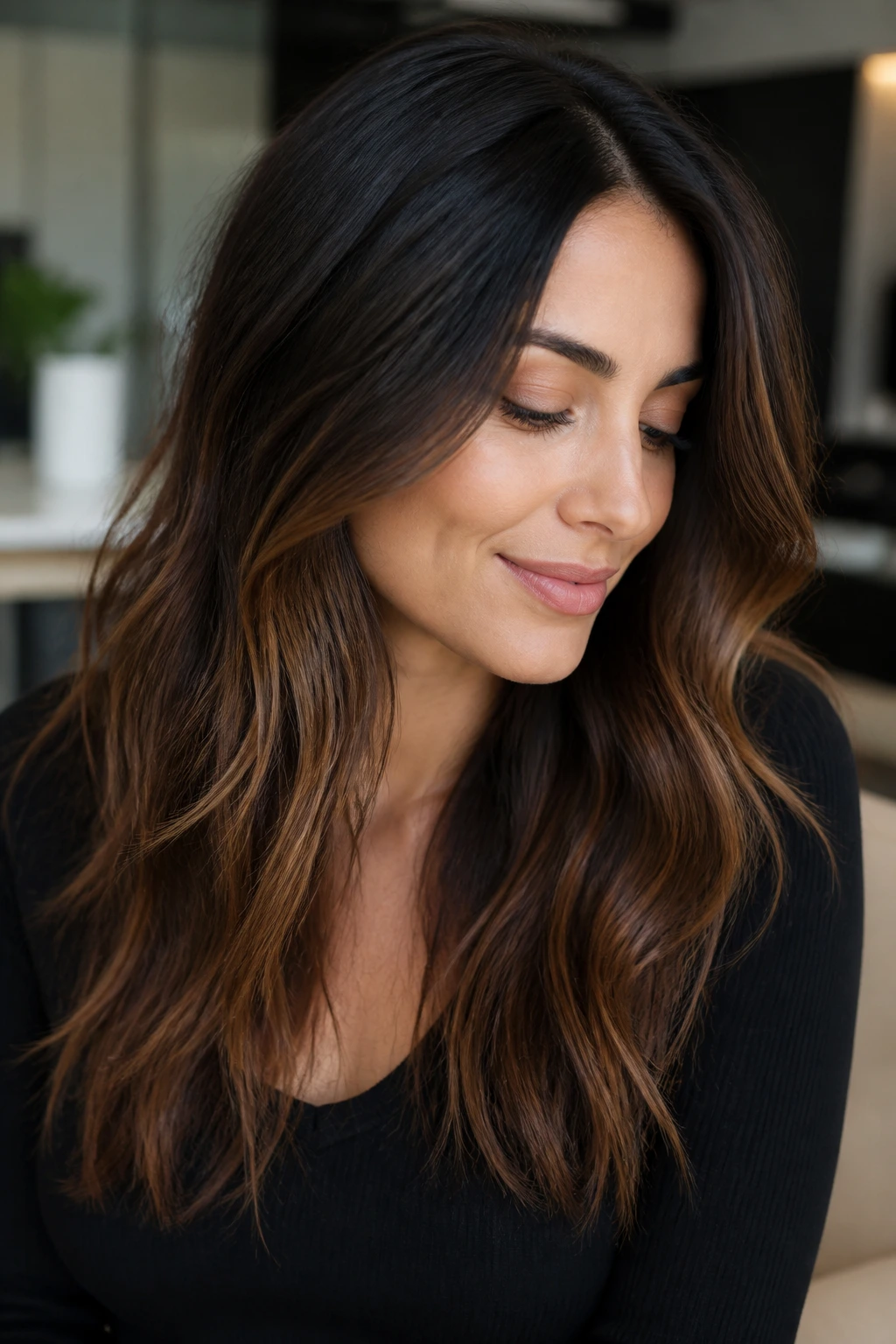 Portrait of a woman with soft ombré from dark brown roots to caramel ends.