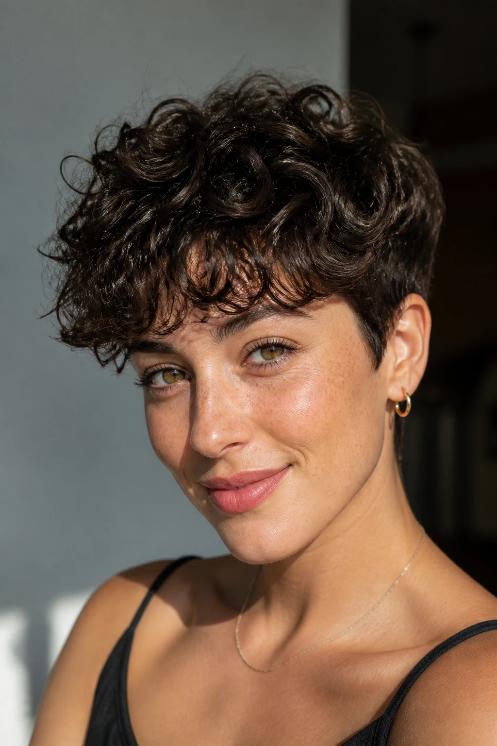 Close-up of woman with soft tapered curly pixie and airy fringe