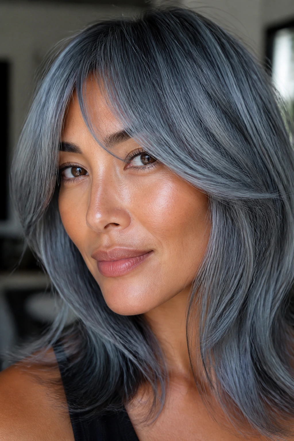 Close-up portrait of a real woman with steel blue-gray hair and cheekbone fringe