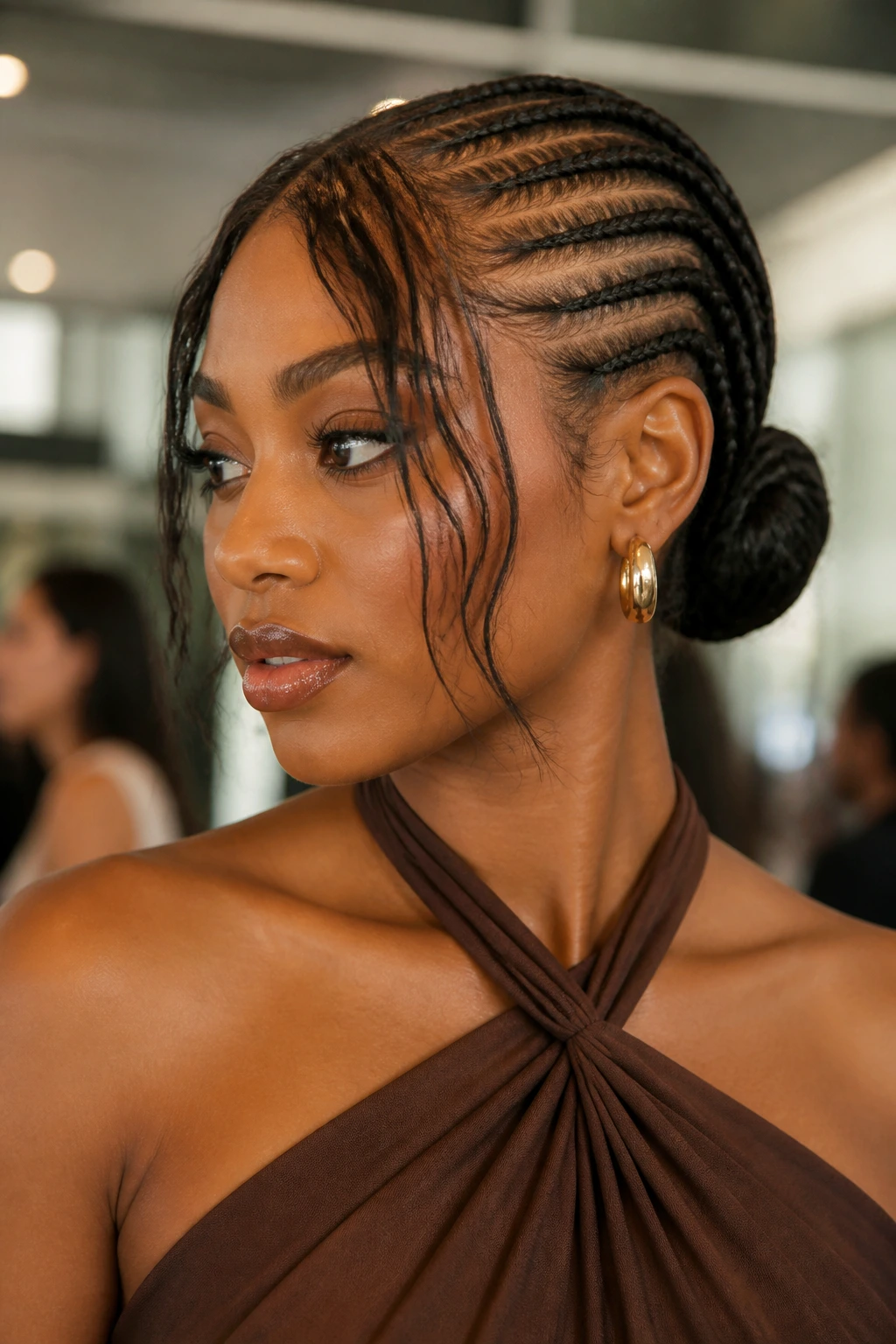Medium close-up of a real woman with stitch braids in a low bun and left-out bangs